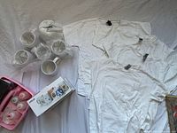 overall lot showing dye bottles in pink tray, bubble-wrapped mugs, box marked Chox, and four white T-shirts