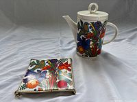 Teapot with lid and matching trivet displayed together