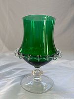 Side view of green vase showing shape, applied crimping, clear stem and foot