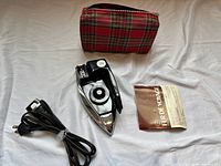 Iron, cord, plaid pouch, instruction leaflet laid out