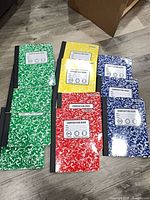 Assorted coloured composition notebooks laid out