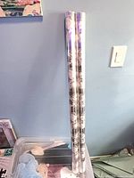 Two long cellophane rolls leaning against wall