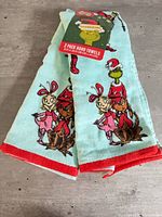 Front view of folded towels with tag, showing Cindy-Lou Who, Max and Grinch graphics