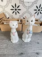 Two porcelain cat figurines front view with pastel flower collars