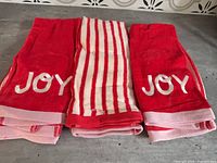 Front view showing three red "JOY" towels and three striped towels folded