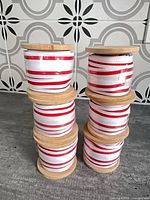 Six stacked wood spools with red/white ribbon