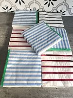 Seven packs of striped napkins laid flat