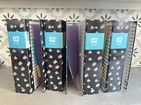 Front view showing patterned covers and 2-inch labels on spines