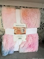 Front of folded faux-fur throw with retail ribbon and tag