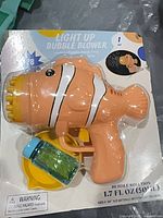 Front of packaged clownfish bubble blower showing toy, bubble solution bottle and tray