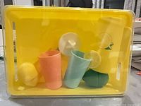 Entire sealed play set in yellow tray showing pitcher, two cups, juicer, lemon halves, slice