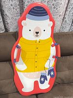 Front view of red foam sled showing polar bear graphic and side handles