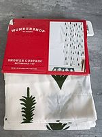 Front of packaged Wondershop shower curtain showing label and folded curtain