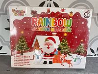 Front of sealed Feredo Kids Rainbow Scratch Notebook box showing Santa graphic and sealed shrink wrap