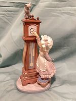 Front view showing full figurine details—girl, clock, cat