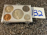 Closed clear plastic case showing all five 1964 coins