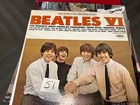 Front cover of Beatles VI album atop stack of vinyl records
