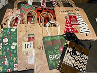 Group of assorted holiday paper gift bags showing multiple designs and sizes