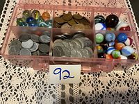 Overall view of container showing marbles and separated coin groups