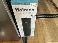 Front of boxed Holmes air purifier showing product image and branding