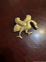 Front view of gold plated stylized bird brooch