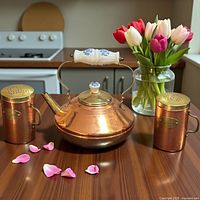 front view of copper kettle with porcelain handle and two copper shakers