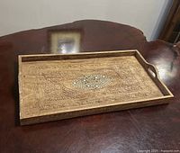 Top view of carved teak tray showing carvings and inlay