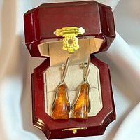 Earrings in burgundy presentation box, frontal view