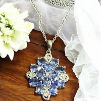 Full necklace laid on wood surface showing chain, bail, and pendant detail