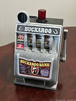 Front view showing Buckaroo branding, reels, lever, and red light