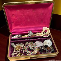 Open jewelry box showing interior lining and all contents