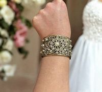 Cuff worn on wrist showing width, gold-tone finish, rhinestone and pearl detailing