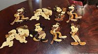 Full set of eleven wooden Disney character plaques spread on table