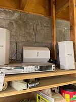 Panasonic DVD receiver and three Emerson speakers on shelf