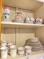 Shelved assortment showing cups, saucers, plates, multiple patterns