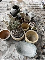 Group view of assorted planters, lanterns, galvanized tub and angel statue on snowy deck