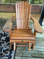 Front view of wooden Adirondack lounger showing slatted back, seat and wide arms