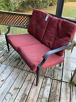 2-person metal loveseat with burgundy cushions on deck