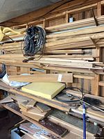 shelf stacked with assorted boards, dowels, trim and plywood offcuts