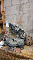 SKIL 3810 miter saw on workbench with loose parts and blade guard