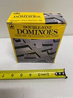 front view of boxed Golden Double-Nine Dominoes with tape measure for scale