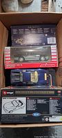 Box containing five boxed die-cast model cars, top view