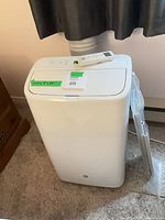 Full view of air conditioner with hose and remote