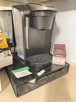 Full view Keurig brewer on pod drawer rack with accessory boxes