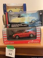 Three boxed cars: Road & Track yellow convertible, 1950 Chevrolet convertible, Majorette Jaguar Type E
