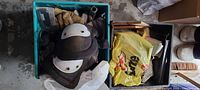 Two crates with knee pads, gloves, yellow bag of accessories, brush visible