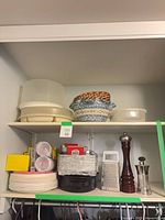 shelf view showing pepper mill, salt grinder, cheese grater, food chopper, disposable items, plastic containers