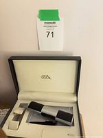 Delvaux case open showing brand and cylindrical item