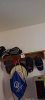 Full view of shelf on wall with caps, bucket hat, drawstring bag
