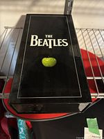 Front view of closed glossy black box with The Beatles logo and green apple